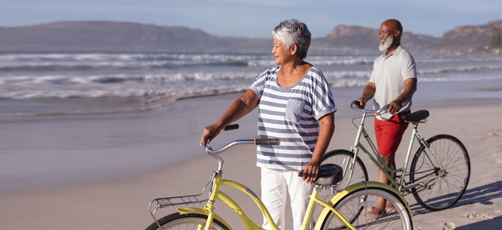A senior man and a woman with their bikes beginning low-impact Cardiovascular Exercise