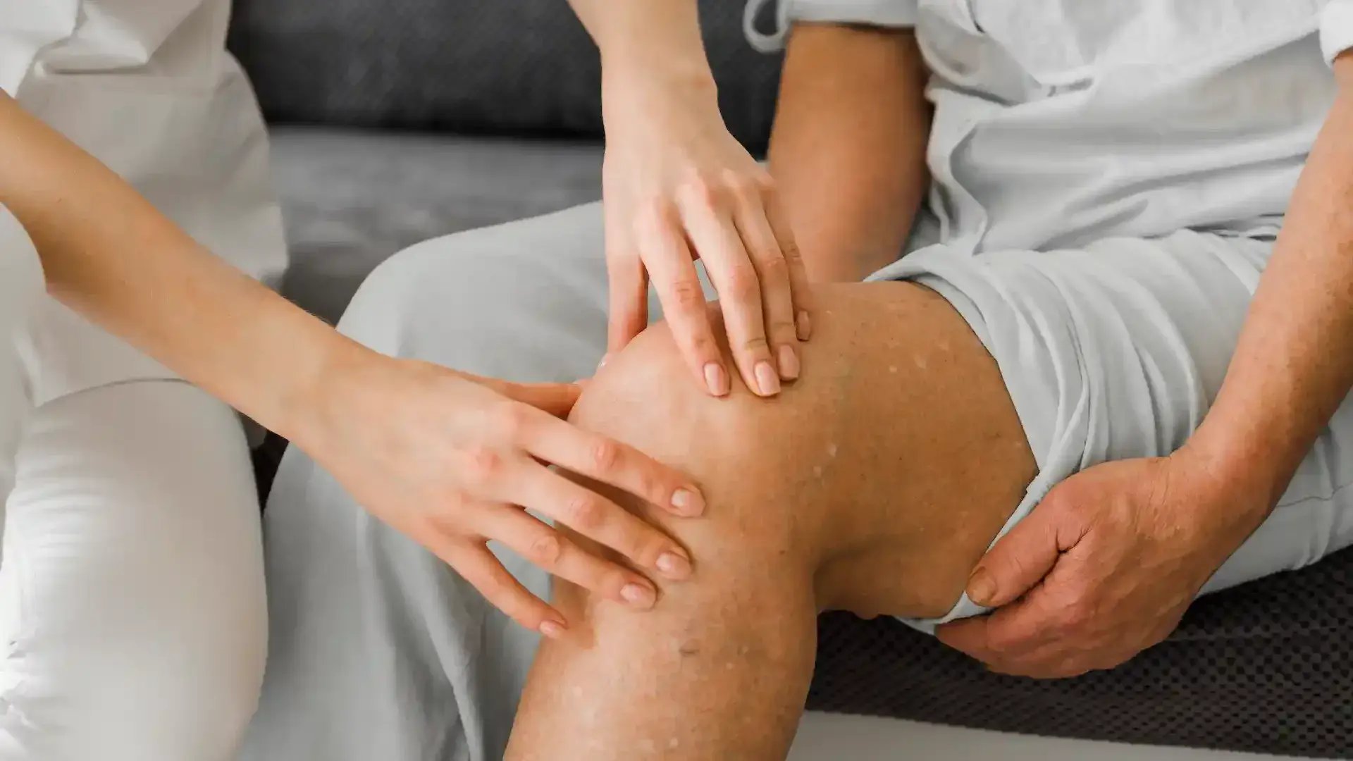 doctor checking senior patient's knee for symptoms and diagnosis of osteoarthritis